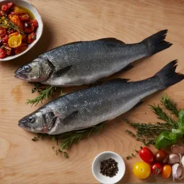Branzino herbs and tomato on wooden background